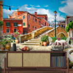 Fototapeten Terrasse mit Tisch und Stühlen und einem Springbrunnen vor einem Gebäude